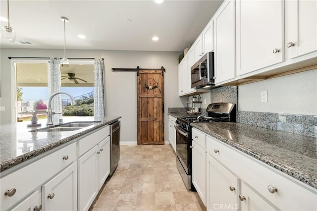 30688 Lone Pine Dr, Menifee, CA 92584 - kitchen featuring appliances with stainless steel finishes, a sink, ceiling fan, a barn door, and white cabinetry
