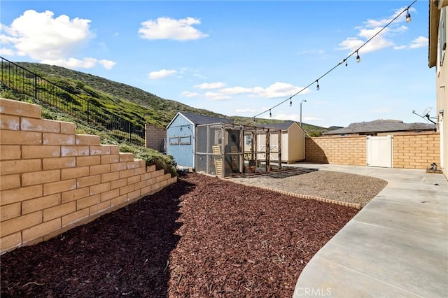 30688 Lone Pine Dr, Menifee, CA 92584 - fenced backyard featuring a mountain view, a patio area, and exterior structure