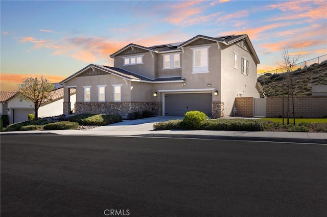 30688 Lone Pine Dr, Menifee, CA 92584 - view of front of property with stone siding, stucco siding, a garage, and roof mounted solar panels