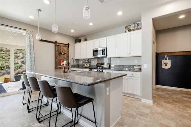 30688 Lone Pine Dr, Menifee, CA 92584 - kitchen with appliances with stainless steel finishes, a sink, a kitchen bar, a center island with sink, and white cabinetry