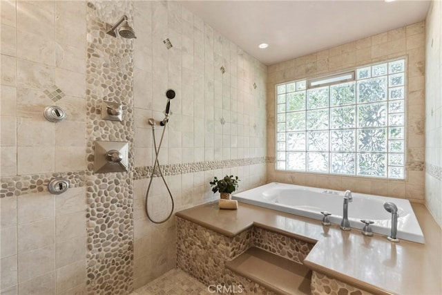 bathroom featuring a tile shower, tile walls, and a tub