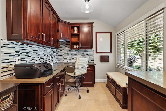 office space featuring baseboards, light tile patterned flooring, built in desk, and lofted ceiling