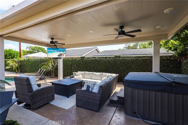 view of patio featuring ceiling fan, a hot tub, an outdoor hangout area, and area for grilling