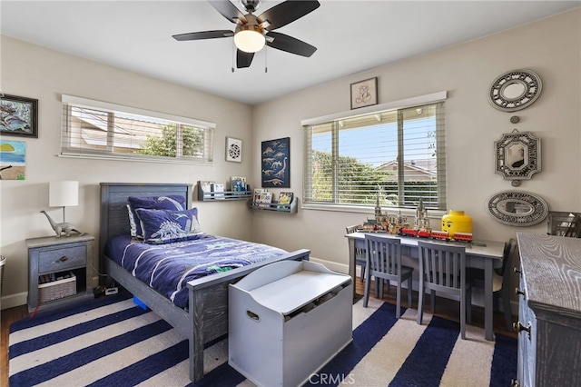 bedroom with a ceiling fan and baseboards
