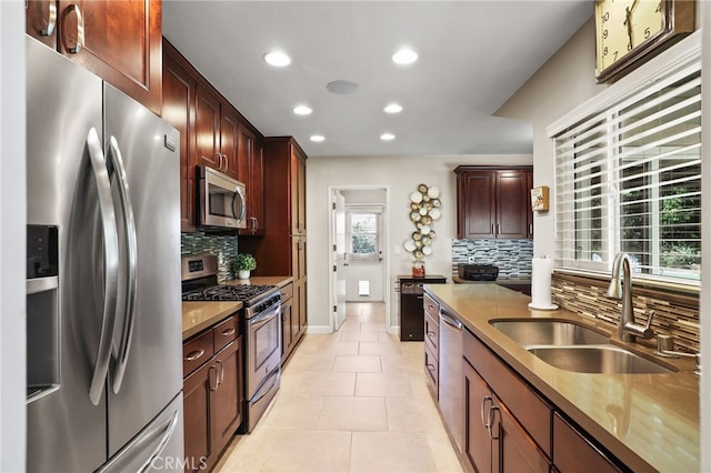 kitchen with tasteful backsplash, a sink, stainless steel appliances, recessed lighting, and light tile patterned flooring