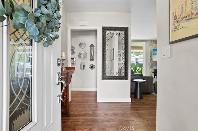 foyer entrance featuring baseboards and wood finished floors