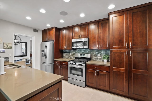 kitchen with a sink, stainless steel appliances, recessed lighting, tasteful backsplash, and visible vents