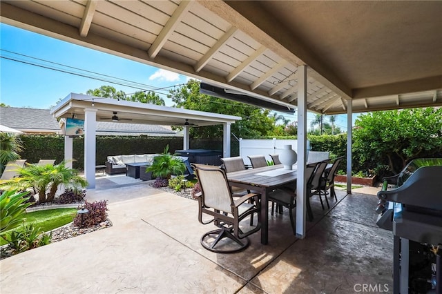 view of patio / terrace with outdoor dining space, a hot tub, ceiling fan, outdoor lounge area, and a fenced backyard