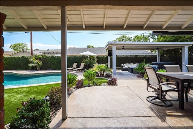 view of patio / terrace with a fenced backyard, a fenced in pool, a jacuzzi, and outdoor dining space