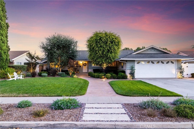 single story home featuring a lawn, an attached garage, and driveway