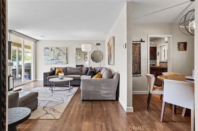 living area featuring baseboards, wood finished floors, and visible vents