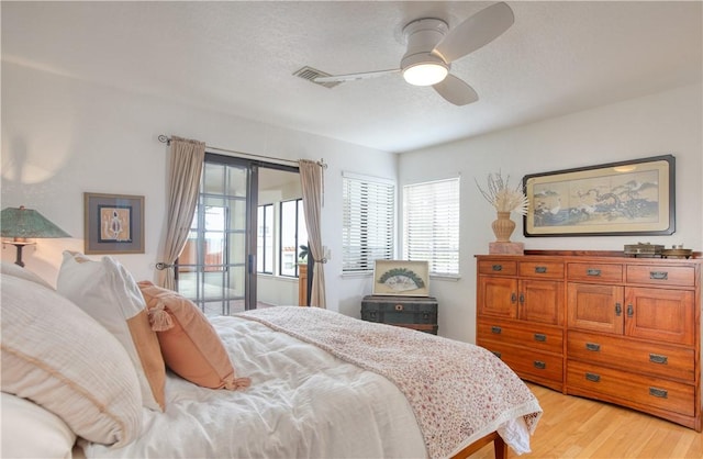bedroom featuring access to outside, multiple windows, visible vents, and light wood-style floors
