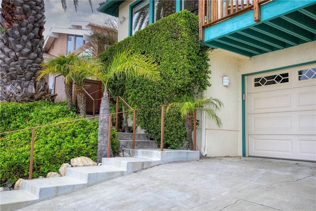 exterior space with a balcony, concrete driveway, and stucco siding