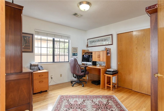 office area featuring visible vents, baseboards, and wood finished floors