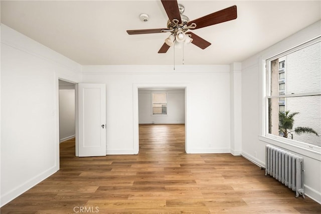 455 E Ocean Blvd Unit 411, Long Beach, CA 90802 - empty room with radiator heating unit, healthy amount of natural light, ceiling fan, and light wood-style flooring