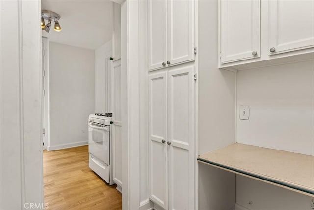 455 E Ocean Blvd Unit 411, Long Beach, CA 90802 - kitchen featuring white gas range oven, white cabinetry, light wood-style flooring, light countertops, and baseboards
