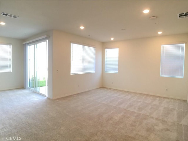 empty room with light colored carpet, visible vents, and recessed lighting