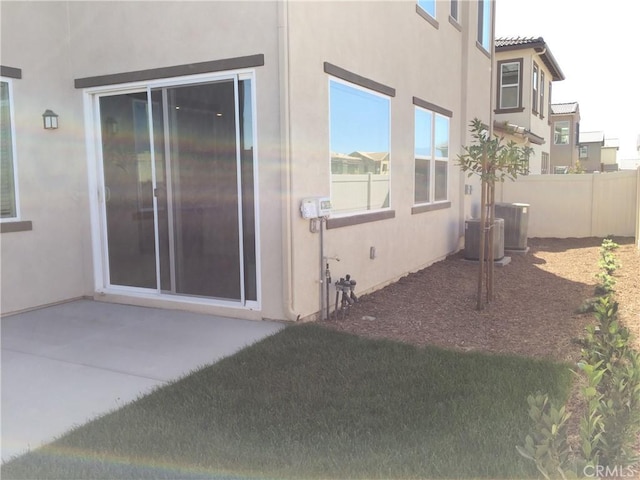 exterior space with stucco siding, fence, and a patio area