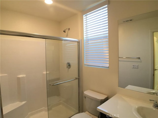 bathroom featuring a shower stall, visible vents, toilet, and vanity