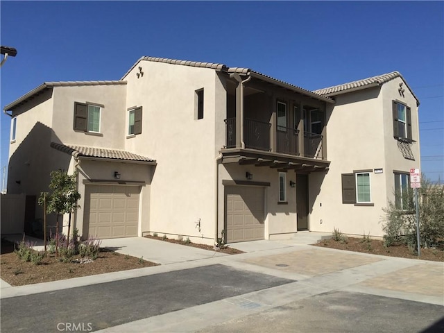 view of front facade featuring stucco siding, driveway, and a garage