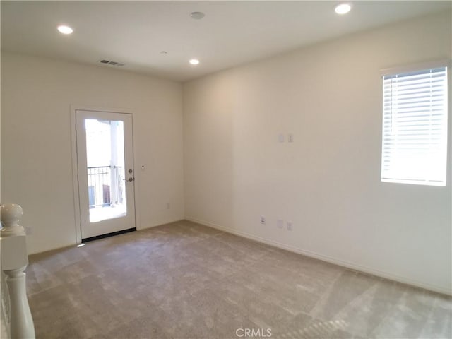 spare room featuring light carpet, baseboards, visible vents, and recessed lighting