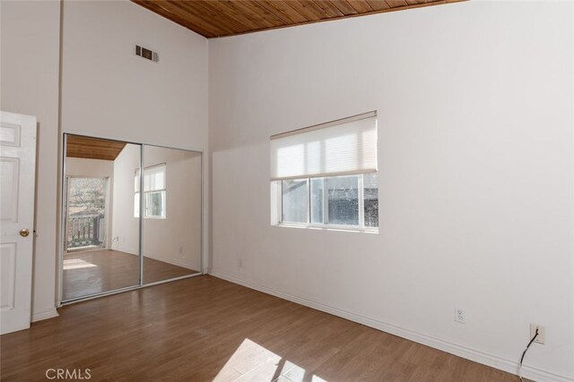 42135 San Francisquito Canyon Rd, Green Valley, CA 91390 - unfurnished bedroom featuring wooden ceiling, wood finished floors, a towering ceiling, baseboards, and a closet