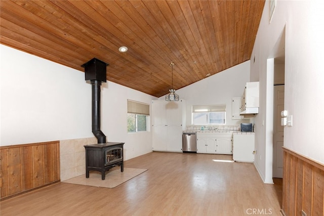 42135 San Francisquito Canyon Rd, Green Valley, CA 91390 - unfurnished living room featuring wooden ceiling, light wood-style floors, a wood stove, lofted ceiling, and wainscoting