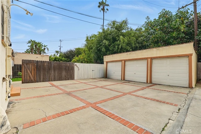detached garage with a gate and fence
