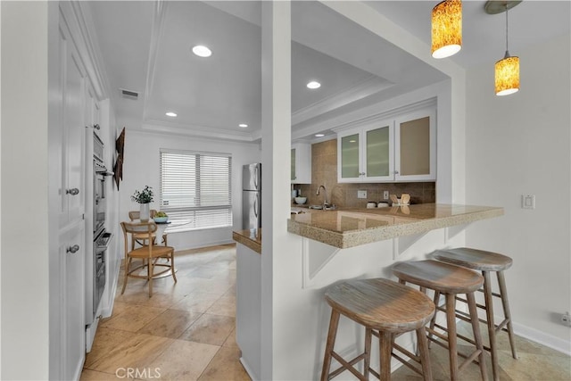 715 3rd St, Hermosa Beach, CA 90254 - kitchen featuring freestanding refrigerator, a tray ceiling, a breakfast bar area, and visible vents