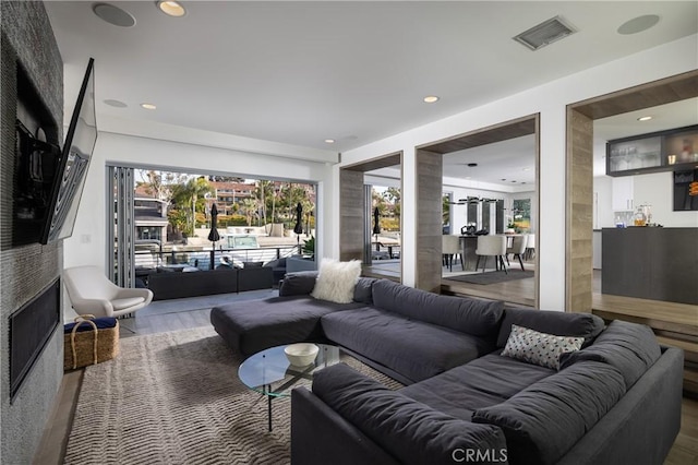 living area with visible vents, wood finished floors, and recessed lighting