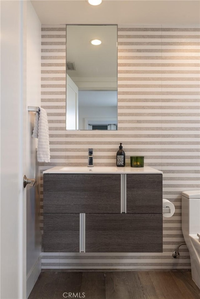 bathroom featuring wood finished floors, vanity, and visible vents
