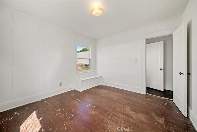 empty room featuring wood-type flooring and baseboards