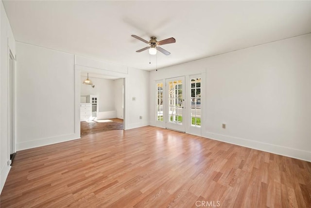 unfurnished living room featuring a ceiling fan, baseboards, and light wood-type flooring