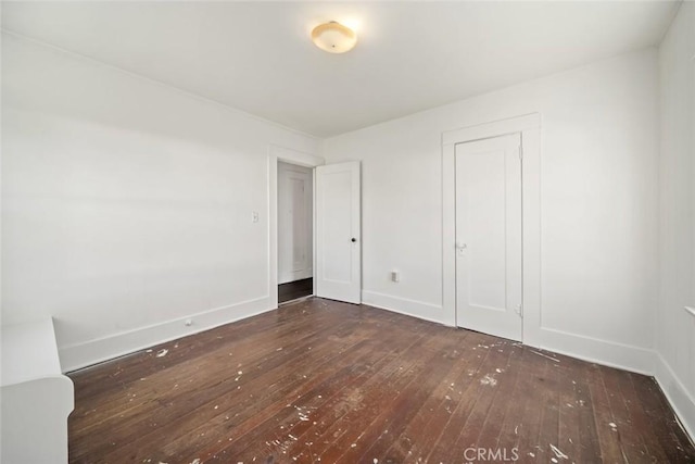 unfurnished bedroom with baseboards and hardwood / wood-style floors
