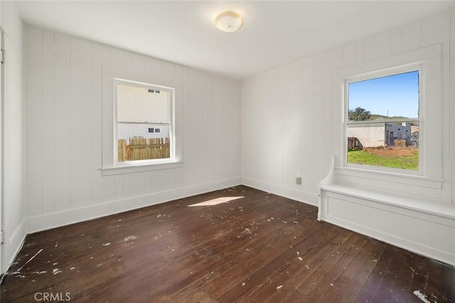 unfurnished room featuring baseboards and hardwood / wood-style flooring