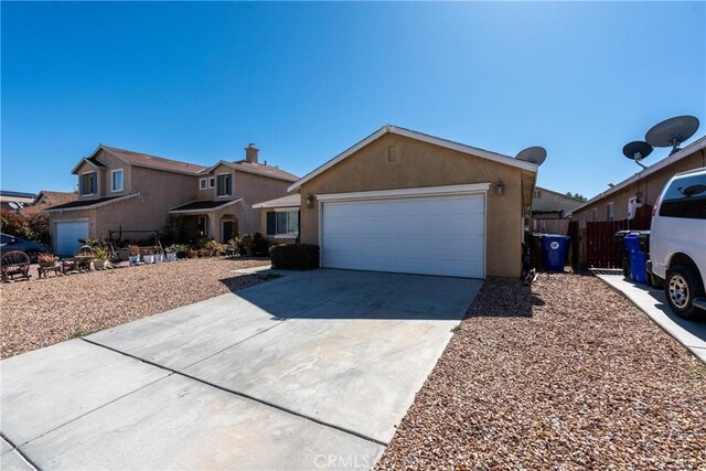 13625 Brynwood St, Victorville, CA 92392 - view of front of home with driveway, an attached garage, and stucco siding