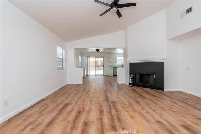 13625 Brynwood St, Victorville, CA 92392 - unfurnished living room featuring a ceiling fan, light wood finished floors, baseboards, a tile fireplace, and high vaulted ceiling