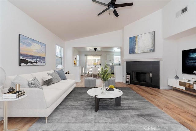 13625 Brynwood St, Victorville, CA 92392 - living area featuring a ceiling fan, a tiled fireplace, wood finished floors, and vaulted ceiling
