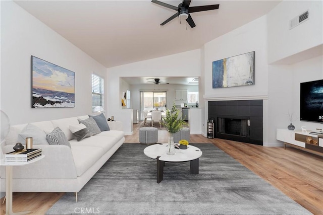 13625 Brynwood St, Victorville, CA 92392 - living room featuring ceiling fan, a fireplace, wood finished floors, and vaulted ceiling