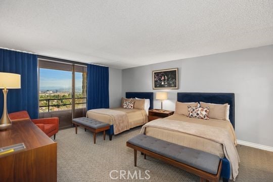 carpeted bedroom featuring baseboards and a textured ceiling