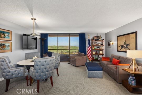 carpeted dining space with a textured ceiling