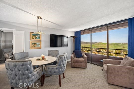 carpeted dining space with a textured ceiling