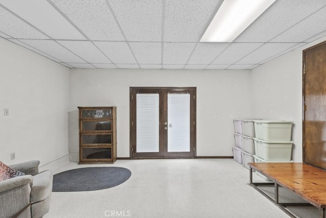 interior space with baseboards, french doors, and a drop ceiling