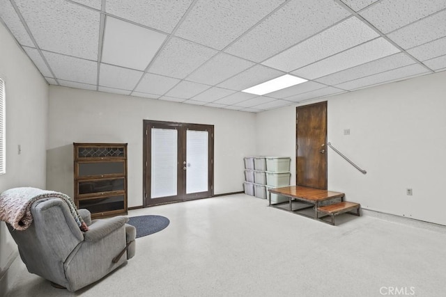 interior space with french doors, baseboards, and a drop ceiling