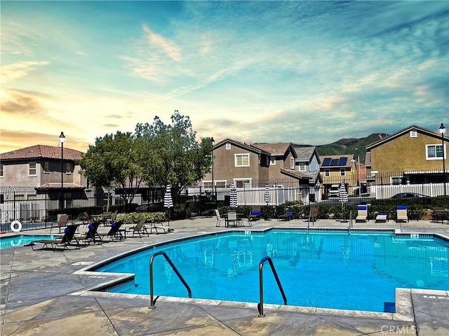 12241 Amaryllis, Yucaipa, CA 92399 - pool at dusk featuring a community pool, a residential view, and a patio