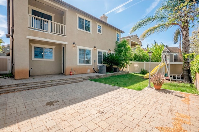 12241 Amaryllis, Yucaipa, CA 92399 - back of property featuring a playground, stucco siding, central AC unit, a patio, and a balcony
