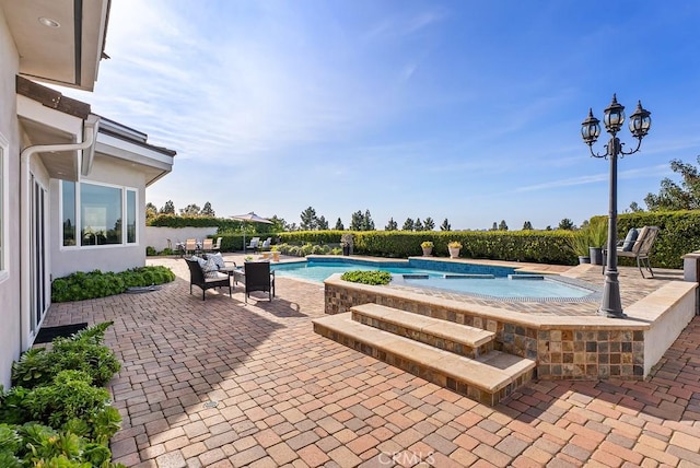 view of pool with a patio area and an outdoor hot tub