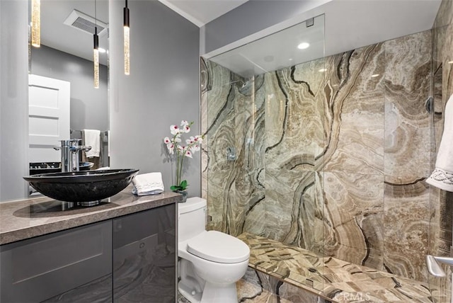 bathroom featuring toilet, a marble finish shower, and vanity