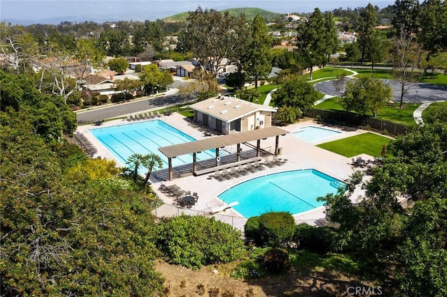 community pool with fence and a patio