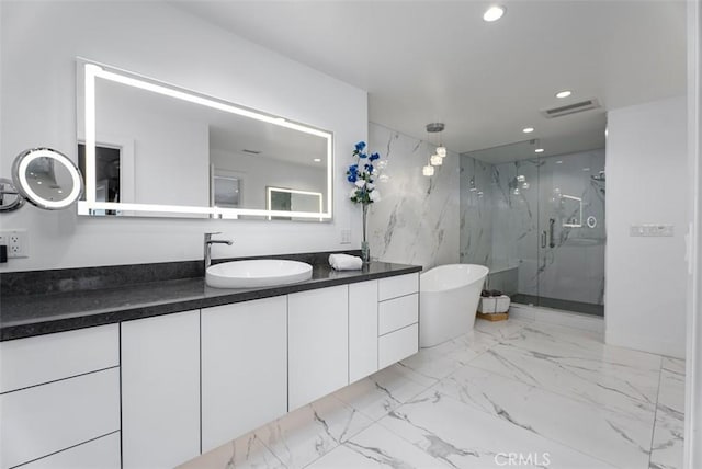 full bathroom with marble finish floors, a marble finish shower, vanity, a soaking tub, and recessed lighting